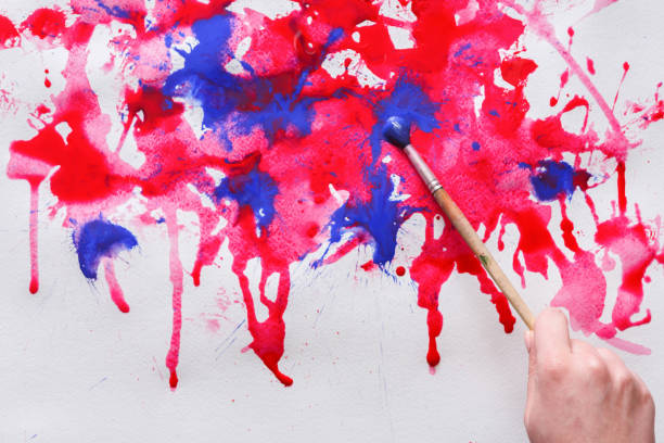 istock Human hand drawing picture, splashing paints 843206506