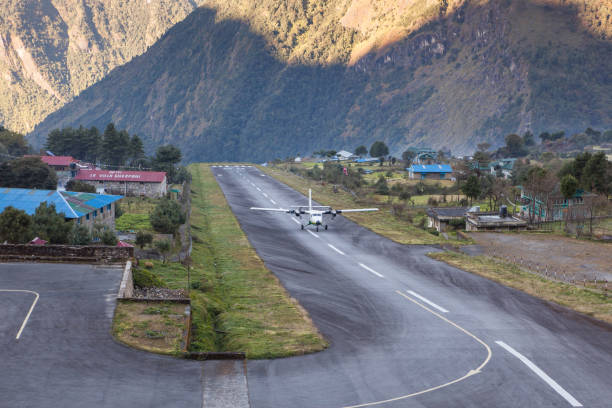 small airplane landing in the tenzing-hillary airport in lukla, himalayas, nepal. airplane landing to the small runway between mountains. - lukla imagens e fotografias de stock