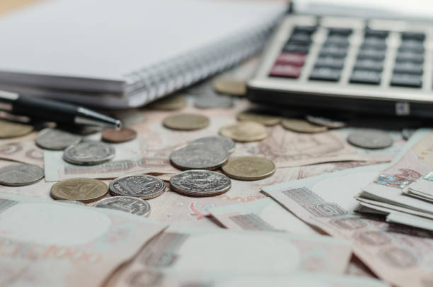 istock money thai banknote with white notebook paper, pen and calculator on  table working in office. concept finance accounting 843211516
