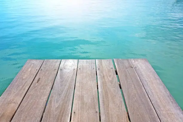 Wooden floor with deep blue sea on background