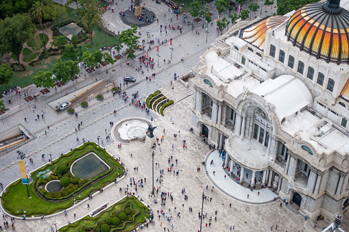 Aerial view over the Palace of fine arts building and traffic in downtown Mexico City during the day.