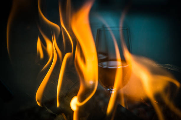 The reflection of two glasses of dessert port red wine in the glass of a log fire fireplace Cape Town Cape Winelands South Africa