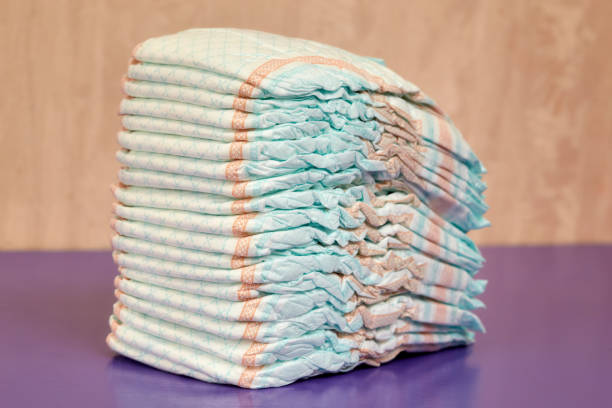 istock Stack of diapers or nappies on purple background 843222404