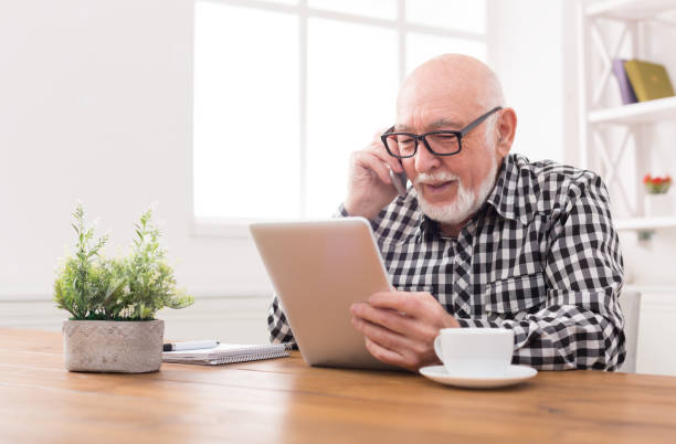 istock Senior man talking on phone with tablet 843222524