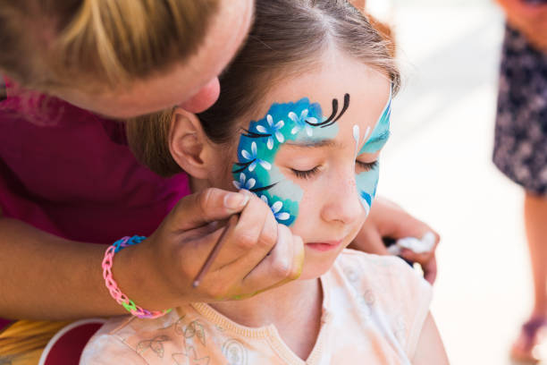 istock Female child face painting, making butterfly process 843229750
