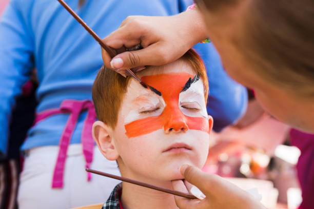 istock Child boy face painting, making tiger eyes process 843230076