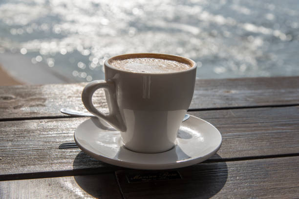 istock Cup of coffee on sea background 843233676