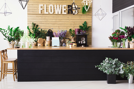 Small business, Flowers delivery. Modern flower shop interior, reception desk. Floral design studio, sale of decorations and arrangements.