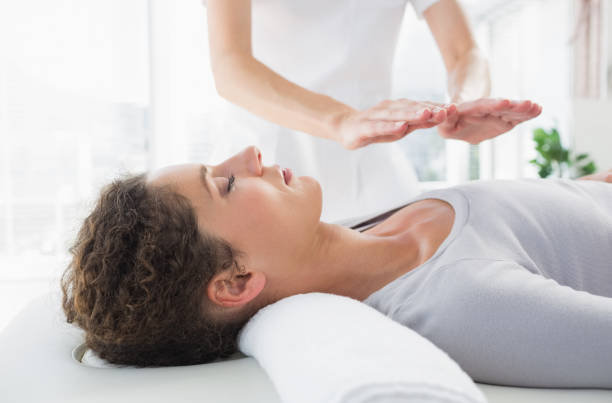 woman having reiki treatment - reiki alternative therapy massaging women imagens e fotografias de stock