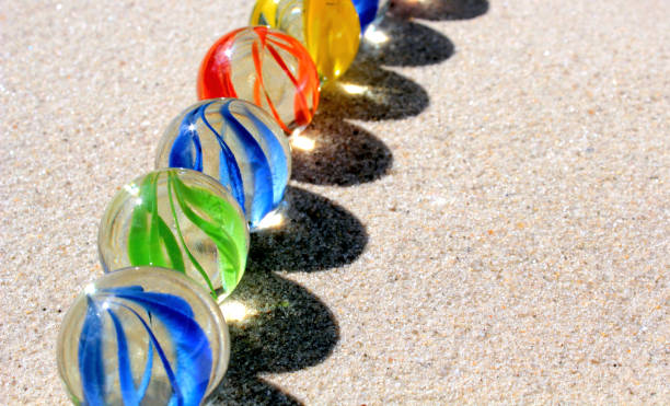 istock Colorful glass marbles on sand 843237906
