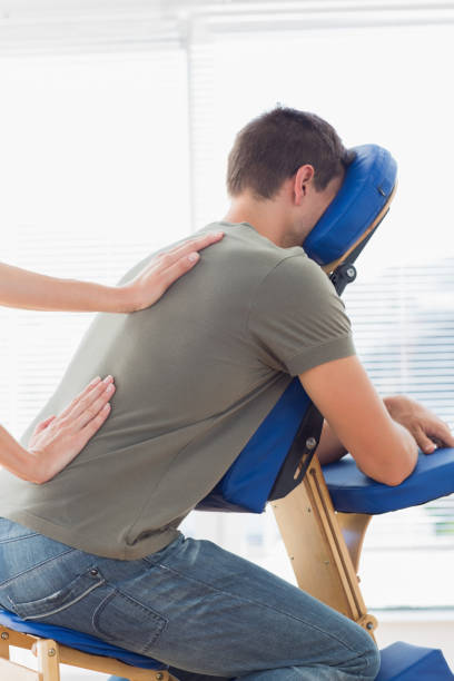 istock Therapist giving back massage to man in hospital 843241430