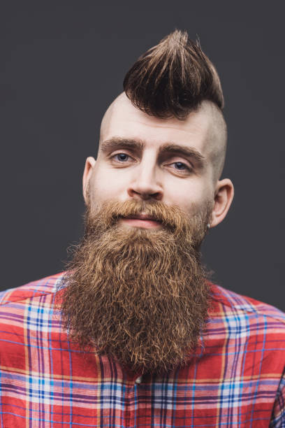 Young trendy man smiling Young punk rocker man portrait. Isolated on gray background man laughing hard stock pictures, royalty-free photos & images