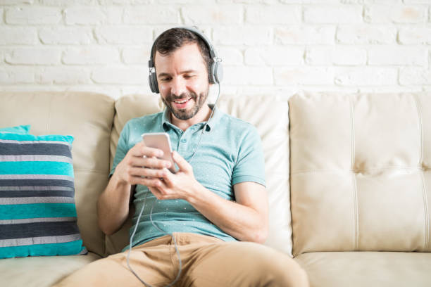 istock Handsome young man listening to music on his phone 843242514