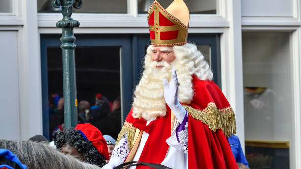 Sinterklaas arriving in the city of Kampen for the Sint Nicolaas festival Arrival of Sinterklaas in the city of Kampen. The old Saint is riding his horse through the crowded shopping street surrounded by his helpers the Black Petes. Sinterklaas is a traditional Dutch holiday for children that is celebrated on the 5th of December. In recent year there is a strong discussion about the role of Zwarte Piet in this culutural tradition. zwarte piet stock pictures, royalty-free photos & images