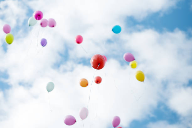 istock festive balloons flying in blue cloudy sky 843245416