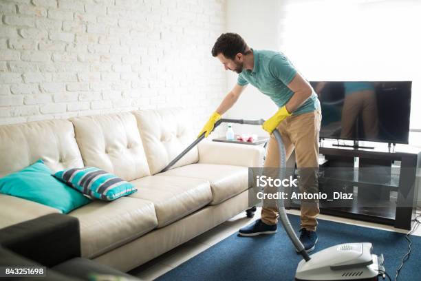 Latin Man Cleaning The Sofa Stock Photo - Download Image Now - Cleaning, Men, Sofa