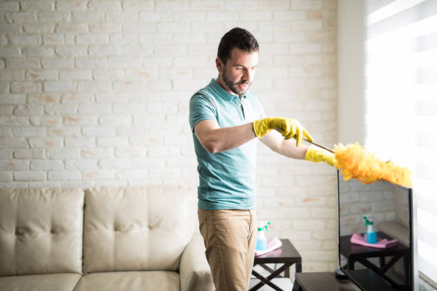 istock Handsome Latin man dusting his house 843252474
