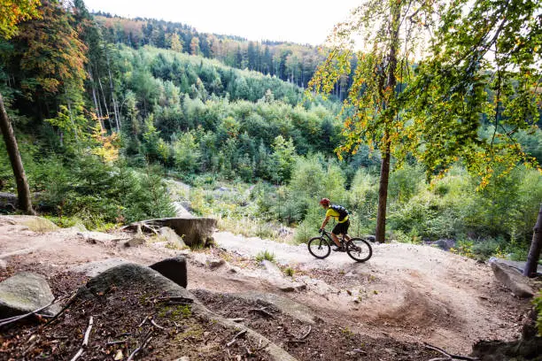 Mountain biker riding on bike in autumn inspirational mountains landscape. Man cycling MTB on enduro trail track. Sport fitness motivation and inspiration.