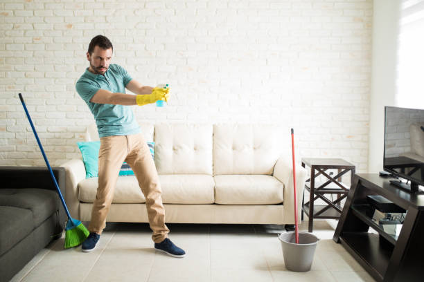 istock Playful man cleaning the house 843252518