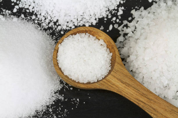 istock Various Salt and wooden spoon on black stone 843253182