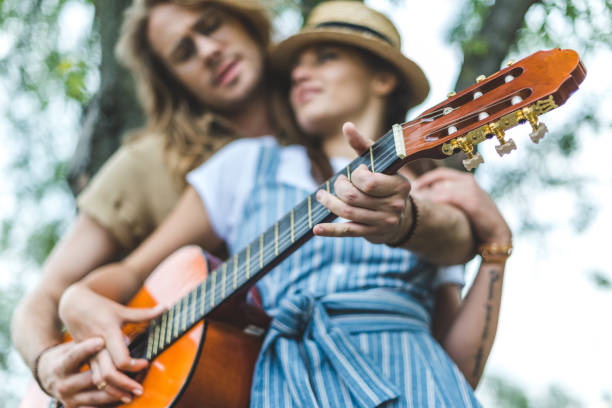 istock couple with guitar in park 843253706