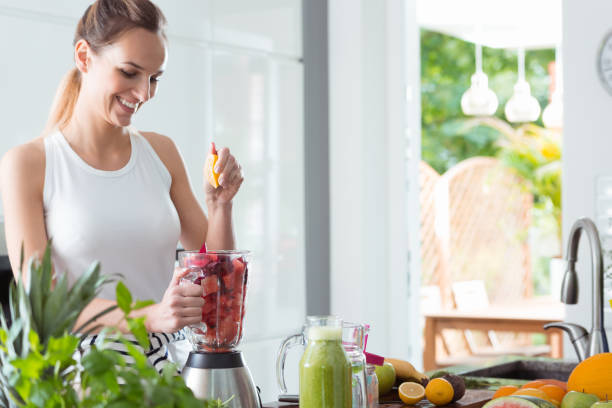 istock Smiling woman squeezing orange juice 843259986