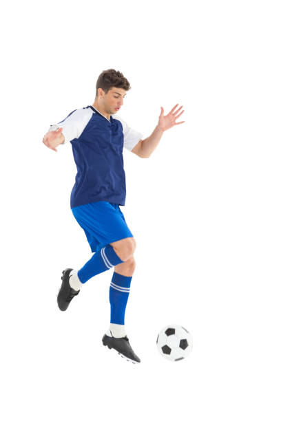 istock Football player in blue jersey kicking ball 843260874