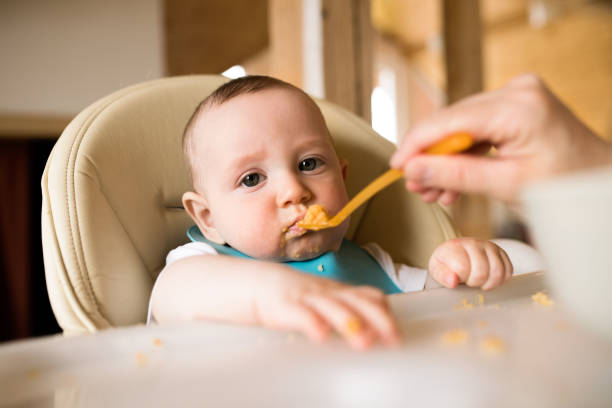 istock Unrecognizable mother at home feeding her baby son. 843261088