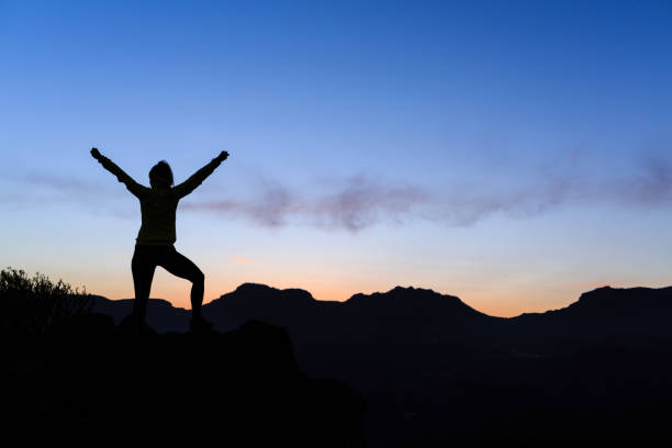 istock Woman climbing success silhouette in mountains sunset 843263518