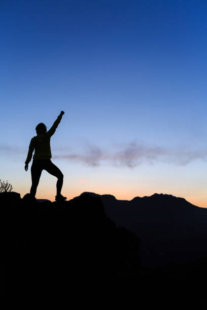 istock Woman climbing success silhouette in mountains sunset 843263962