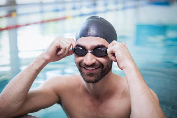 istock Smiling man wearing swim cap and goggles 843264752