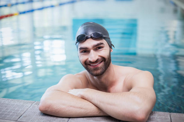 istock Smiling man wearing swim cap and goggles 843264836