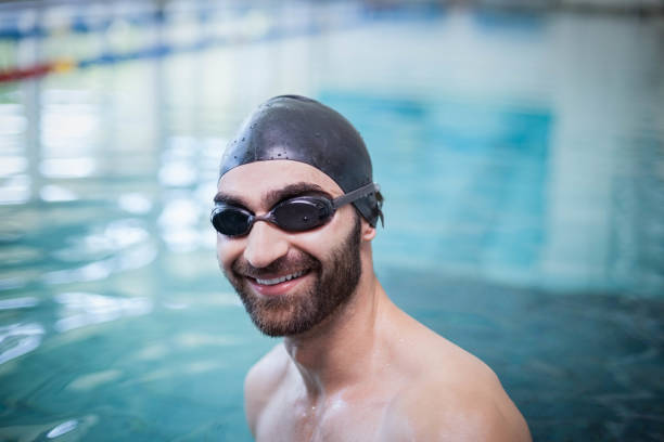 istock Smiling man wearing swim cap and goggles 843264918