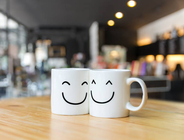 Two happy cups on coffee store blur background, Valentine lover concept stock photo