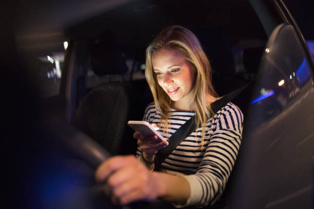 istock Woman with smartphone in her car at night. 843266592
