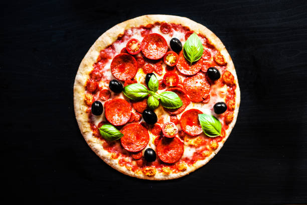 istock Meat Pizza with Ham, Pepperoni and Bacon on a black background 843276586