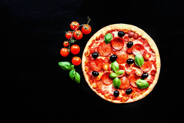 istock Meat Pizza with Ham, Pepperoni and Bacon on a black background 843276668