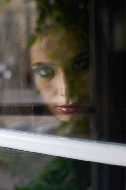 istock Unhappy beautiful brunette woman with make up looking through window 843284890