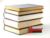 Omani flag with pile of books isolated on white background