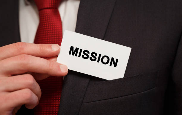 Businessman putting a card with text Mission in the pocket