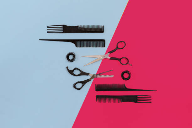 Hairdresser tools on blue and pink background with copy space, top view, flat lay