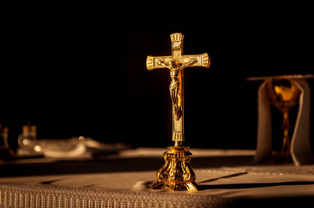 croce cattolica su altare in chiesa illuminata dalla luce del sole - church altar indoors dark foto e immagini stock