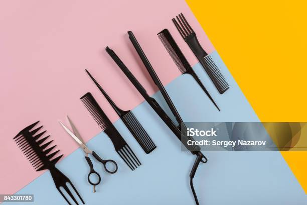 Various Hair Styling Devices On The Color Blue Yellow Pink Paper Background Top View Stock Photo - Download Image Now