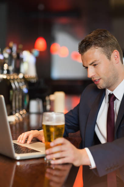 istock Businessman having a drink while working on his laptop 843305734