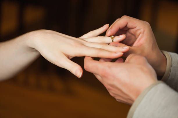 istock Close up on man putting on ring during marriage proposal 843308832