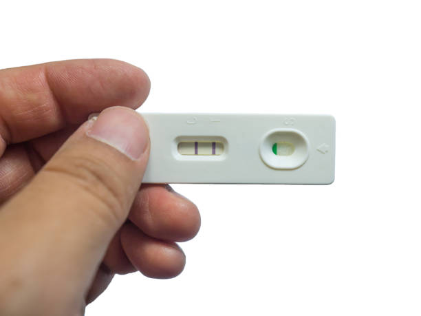 男は、彼の手は、白い背景で隔離の肯定的な妊娠検査を保持しています。 - pregnancy test human pregnancy two objects isolated ストックフォトと画像