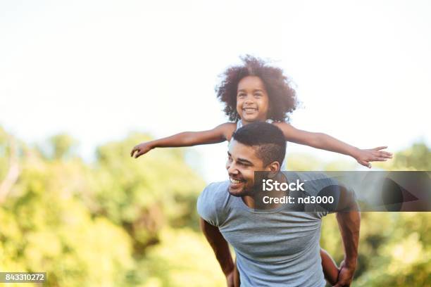 Portrait Of Young Father Carrying His Daughter On His Back Stock Photo - Download Image Now