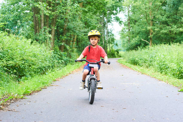 istock Child boy on a bicycle on bicycle path in summer. 843314548