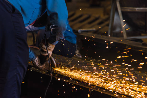 istock Worker using electric wheel grinding on steel structure in factory. 843318358