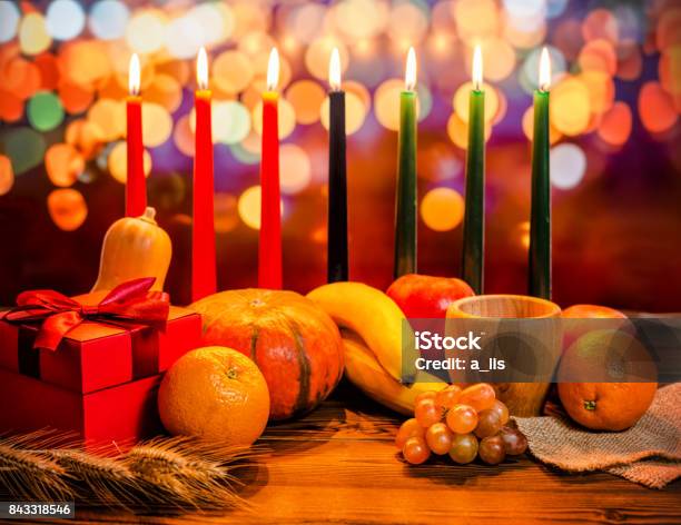 Concepto De Día De Fiesta De Kwanzaa Con Decorar Siete Velas Rojo Negro Y Verde Caja De Regalo Calabaza Tazón De Fuente Y Fruto De Luz Desenfocar Fondo Bokeh Foto de stock y más banco de imágenes de Kwanzaa